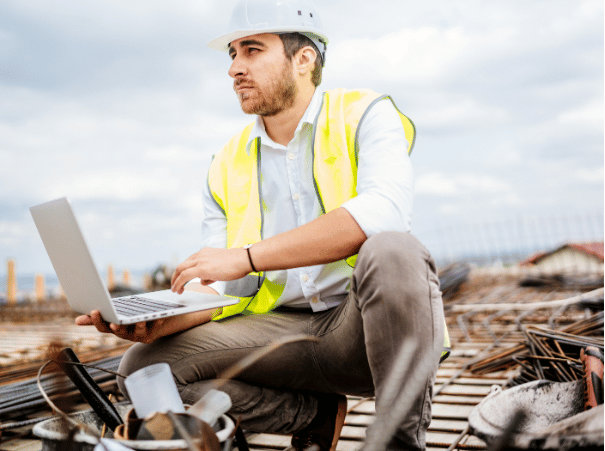 Construction worker holding laptop onsite