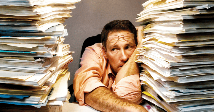 A man overwhelmed by paperwork