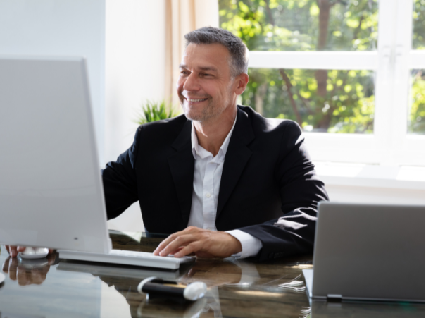 Business man smiling looking at computer screen